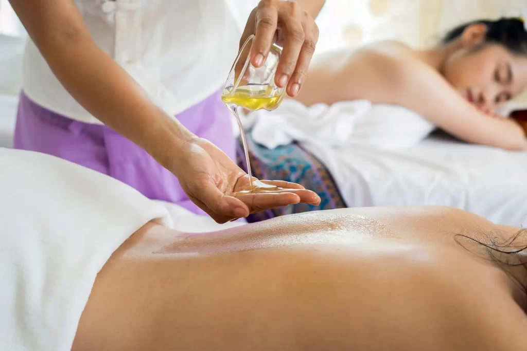 A woman receiving a massage with oil on her back, promoting relaxation and relieving muscle tension.