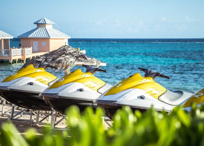 A row of jet skis parked on the sandy beach, ready for an exciting ride on the water.